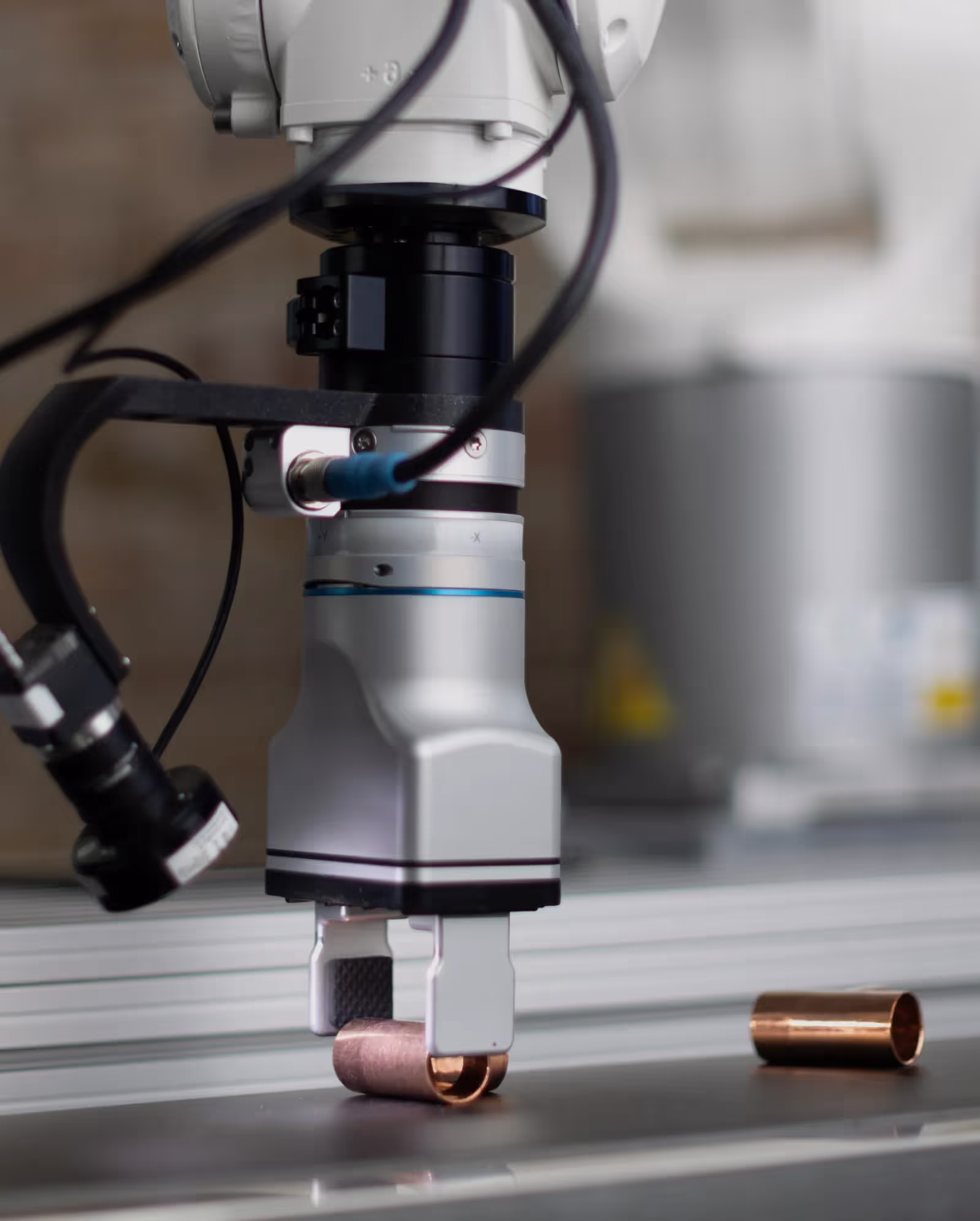 A robot arm equipped with MIRAI AI vision system picking up a small object